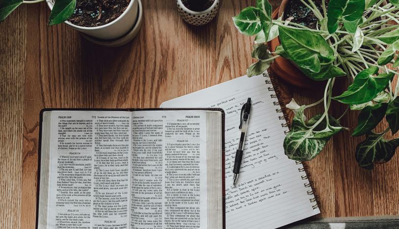 Bibel und Notizbuch auf Tisch